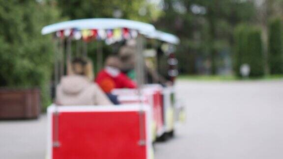 人们乘坐红色旅游火车车厢城市公园娱乐火车娱乐