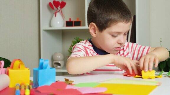 一个小男孩在玩用折纸做成的章鱼雕像