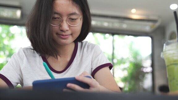 亚洲家庭年轻的青少年和母亲度假放松使用数字平板电脑和智能手机在家里做作业放松与在线游戏和在社交网络上的短信