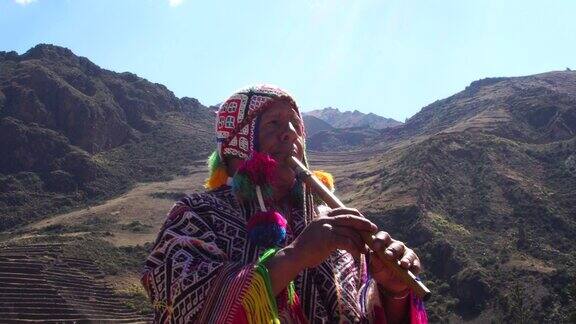 老人穿着秘鲁传统服装吹着笛子
