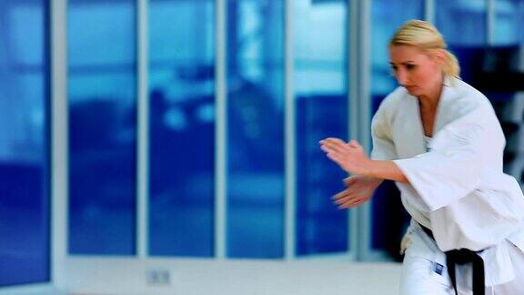女运动员在体育馆里用手表演空手道技巧