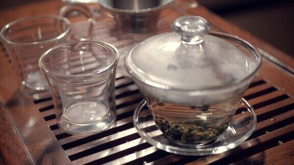 在木制茶几上用玻璃杯盖丸冲泡乌龙茶