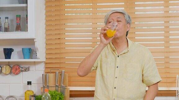 亚洲老年人在家厨房喝橙汁退休生活方式积极的老年人健康