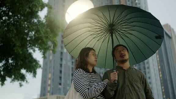 一对亚洲夫妇在下雨天打着伞一起散步