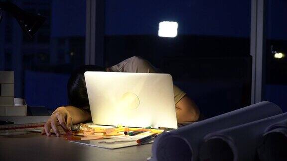 漂亮的亚洲女人工作到很晚思考与严肃的行动在桌子前的电脑显示器桌面