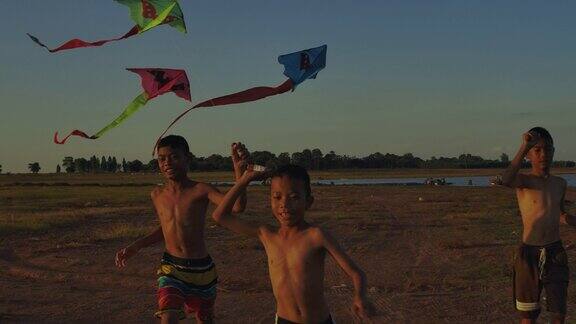三个孩子在乡村的夕阳下追着风筝