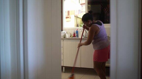 成熟的女人在家里扫地