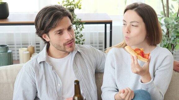 一对夫妇一边在家聊天一边享用披萨和啤酒