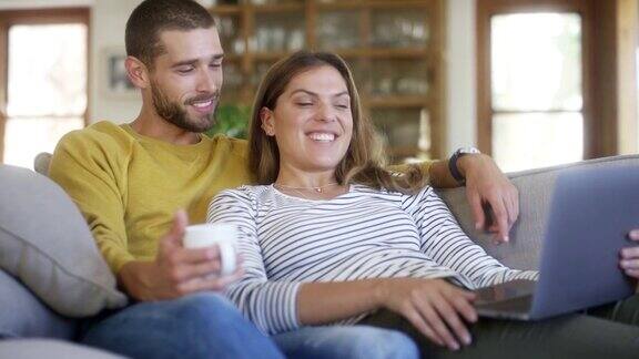 微笑的女人和男人在家里使用笔记本电脑