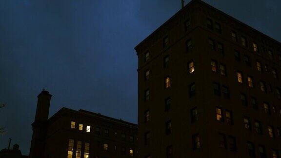 夜间摄像机拍摄了这座城市的一座砖砌公寓楼