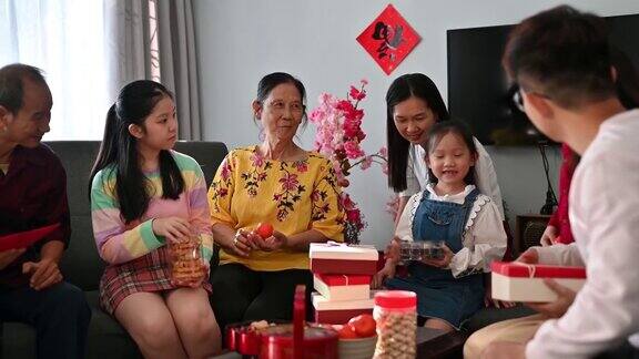 欢乐的亚洲家庭三代欢聚在客厅庆祝中国新年享受传统美食