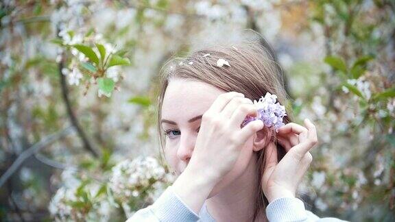 年轻女子的肖像在花园女孩在她的头发上枝丁香