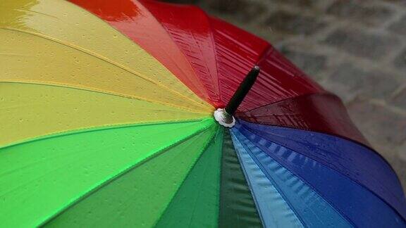五颜六色的雨伞在雨中的人行道上