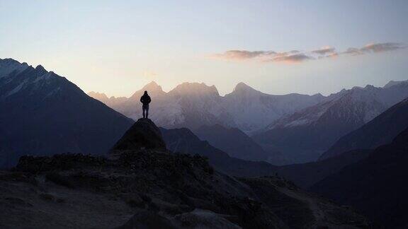 一个人站在岩石上看着喜马拉雅山上的河流