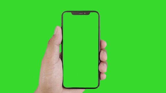 男士手持绿色屏幕的黑色智能手机触摸或按下显示男士使用绿色背景的色度键触摸手机