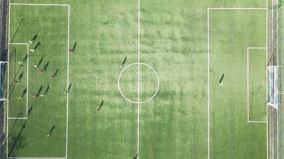足球运动员在绿色的体育场踢足球的鸟瞰图