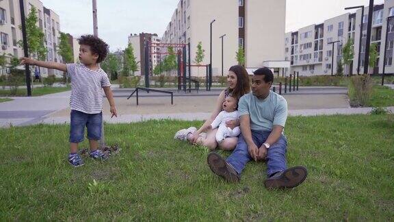 一个混合种族的家庭有两个孩子在夏天在外面玩耍