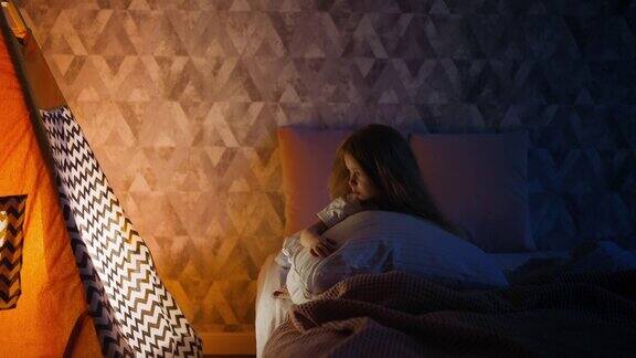 孤独的小女孩抱着枕头在床上看房子