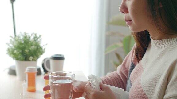 有魅力的女人在家庭房间里吃药喝水