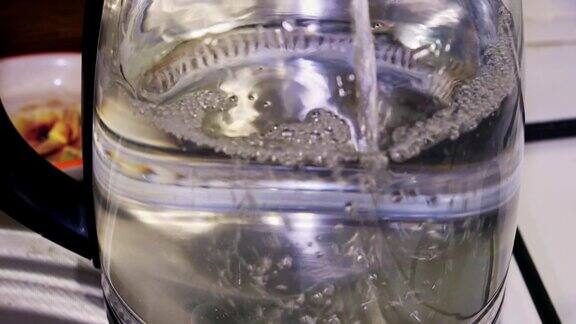 水倒进一个透明的玻璃电水壶