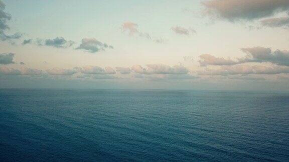 在多云的天空下日落时蓝色平静的海浪4k的视频