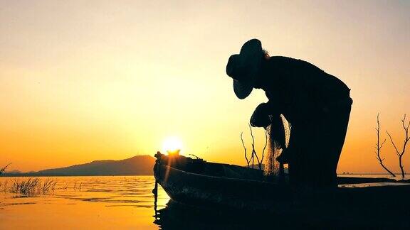 泰国日落时分渔民在长尾渔船上捕鱼