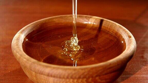 用金属勺子在木碗里舀蜂蜜动作缓慢