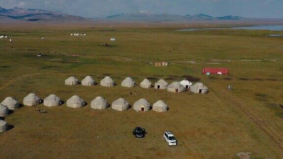 在吉尔吉斯斯坦的松科尔湖一名女游客在风景优美的帐篷营地享受早晨的鸟瞰图
