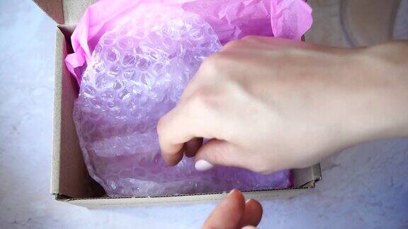 刮痧按摩器玉辊在女性手中粉玉石礼盒用于面部和身体护理