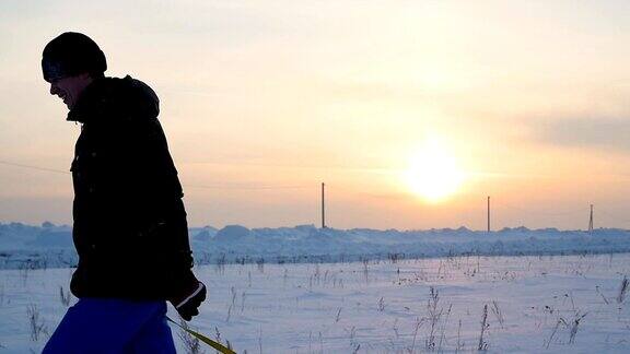 那家伙拿着雪筒爬上了雪山缓慢的运动雪的冬天的风景日落时间
