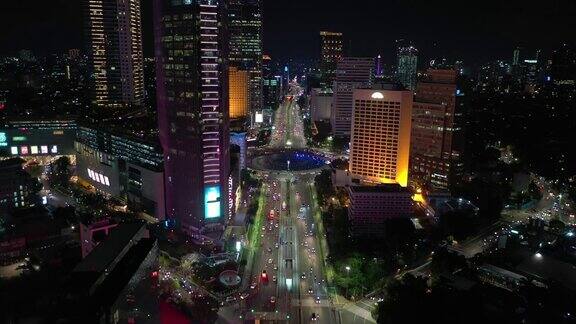 夜间灯光照亮雅加达市中心交通、街道圈、喷泉空中全景4k印尼