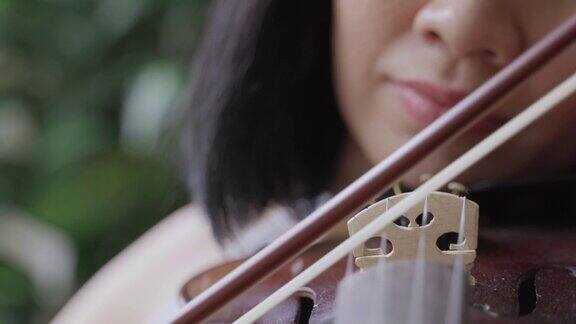 一名亚洲女子在隔离期间在家拉小提琴