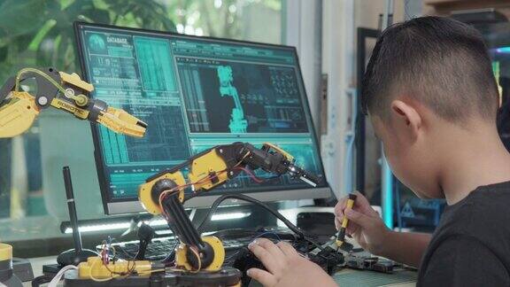 教育主题:男孩控制机器人手臂在数字平板科学工程教育技术