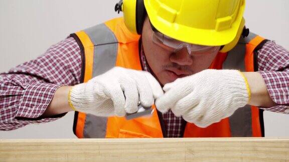 年轻的亚洲工匠搬运木材和检查木材质量为良好的建设者服务的家木匠在统一的工作在工作室孤立的白色背景4k决议