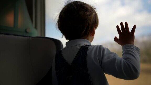 孩子乘火车旅行小男孩看着窗外的风景经过