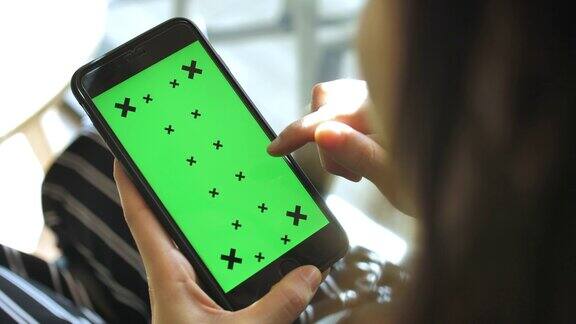 年轻女子使用绿色屏幕的智能手机