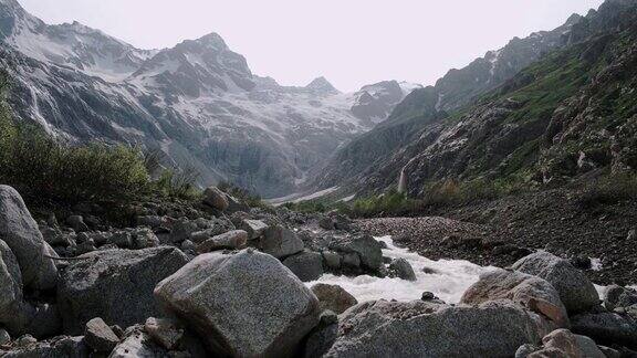 湍急的山河在岩石间流动山上的雪和冰川
