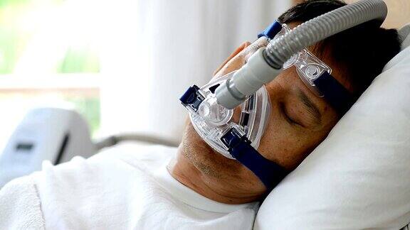 睡眠呼吸暂停治疗男人戴着呼吸面罩睡在床上