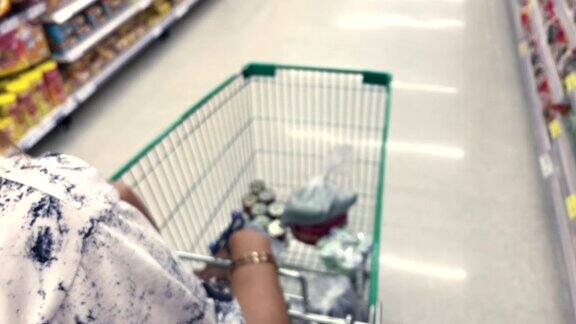 一个女人在超市里推着购物车