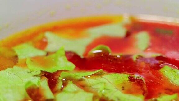 奶油蔬菜红汤厨师搅拌并加入生菜和奶油小的甜点匙和碗光滑的旋转