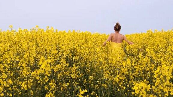 穿黄衣服的女人跑过油菜花田