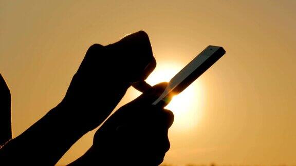 日落时分一名女子在森林里使用智能手机