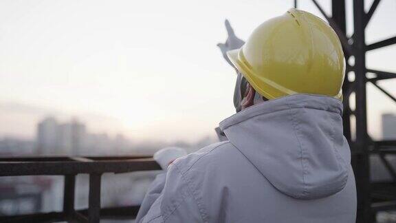 亚洲高级工程师戴着安全帽在工地上工作的背影
