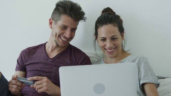 年轻夫妇用笔记本电脑在网上购物