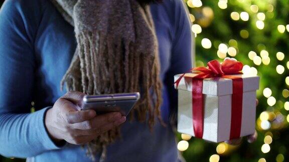 女人用手机与礼盒庆祝圣诞和新年慢镜头