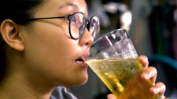 年轻的亚洲女人喝啤酒