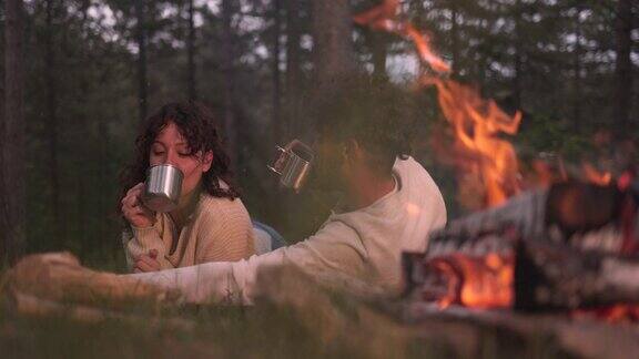一对幸福的年轻夫妇在大自然中享受篝火