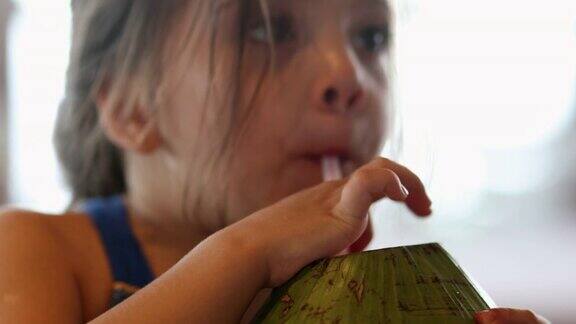 小女孩用吸管喝椰子汁