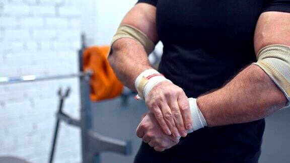 运动员矫正手腕和手部肌肉上的弹性绷带为健身房训练做准备特写