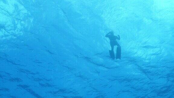 一名潜水员在水面附近踩水的慢动作镜头